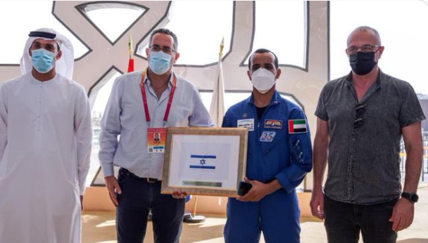 فضيحة.. رائد الفضاء الإماراتي يهدي الصهاينة علماً لكيانهم رافقه في رحلته الفضائية قبل عام من 
